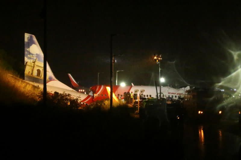 Rescue workers look for survivors after a passenger plane crashed when it overshot the runway at the Calicut International Airport in Karipur