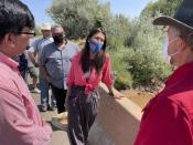 This Aug. 31, 2021 photo shows U.S. Rep. Teresa Leger Fernández, center, talking with acequia officials at a crossing over the Rio Chama during a tour near Abiquiu, New Mexico. The traditional irrigation systems known as acequias are facing pressure amid persistent drought and warming temperatures. (AP Photo/Susan Montoya Bryan)