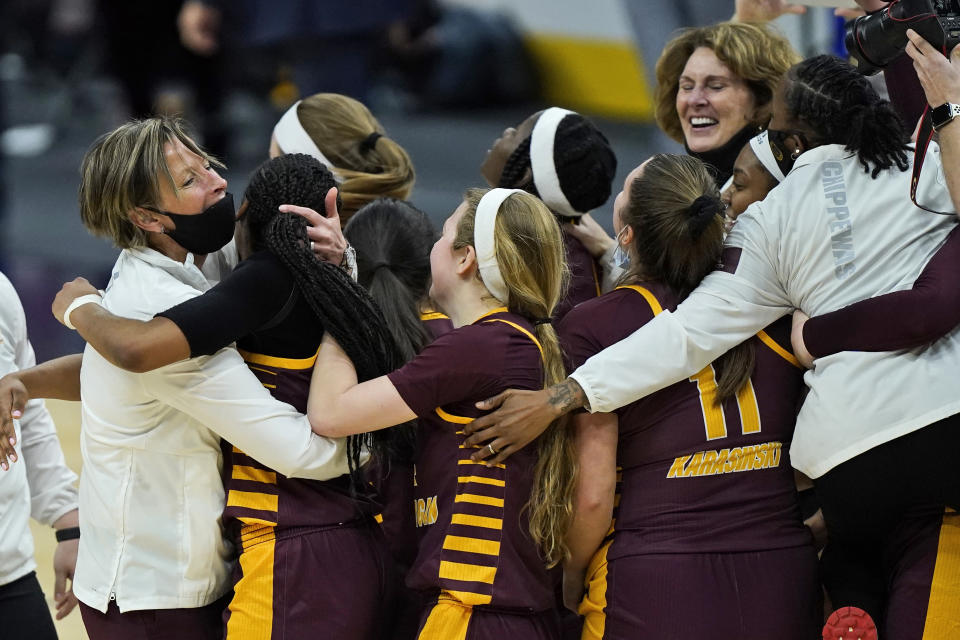 Central Michigan's head coach Heather Oesterle, left, celebrates with teammates after defeating Bowling Green 77-72 in an NCAA college basketball game in the championship of the Mid-American Conference tournament, Saturday, March 13, 2021, in Cleveland. (AP Photo/Tony Dejak)