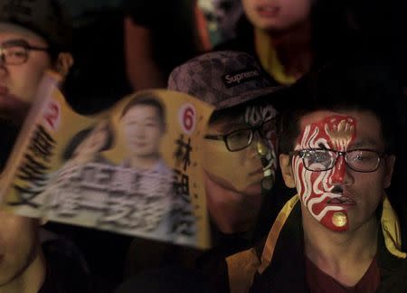 Supporters of Freddy Lim, a candidate to the 2016 legislative election and singer of death metal band Chthonic, wave a flag with images of Taiwan's main opposition Democratic Progressive Party (DPP)'s Chairperson and presidential candidate Tsai Ing-wen and Lim, during a concert to boost Lim's campaign in Taipei, Taiwan, December 26, 2015. REUTERS/Pichi Chuang