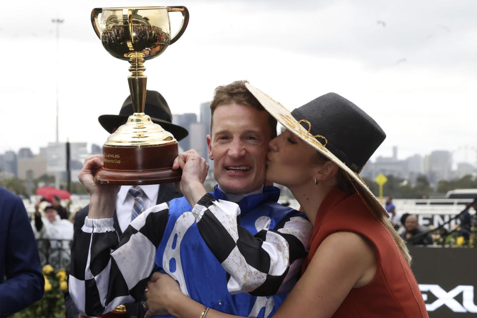 Jockey Mark Zahra holds his trophy as his wife, Elyse, kisses him after winning the Melbourne Cup horse race on Gold Trip in Melbourne, Australia, Tuesday, Nov. 1, 2022. (AP Photo/Asanka Brendon Ratnayake)