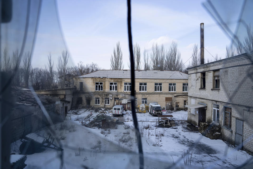 A view of the yard of hospital which was damaged by Russian shelling is seen from a broken window in Krasnohorivka, Ukraine, Sunday, Feb. 19, 2023. (AP Photo/Evgeniy Maloletka)