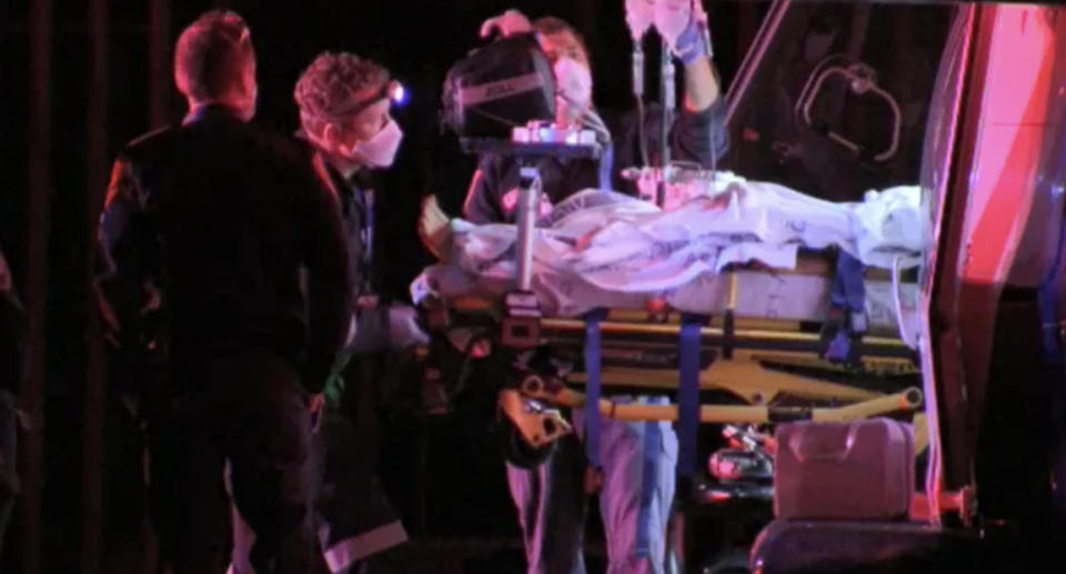 Emergency services put a stretcher into a helicopter at a scene where a baby was found dead.