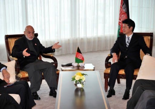 Afghanistan's President Hamid Karzai (L) speaks to Japanese Foreign Minister Koichiro Gemba during their talks in Tokyo, on July 8. Donor nations readied Sunday to pledge $16 billion for Afghanistan to prevent the country from sliding back into turmoil when foreign combat troops depart, but the aid was expected to come with strings attached