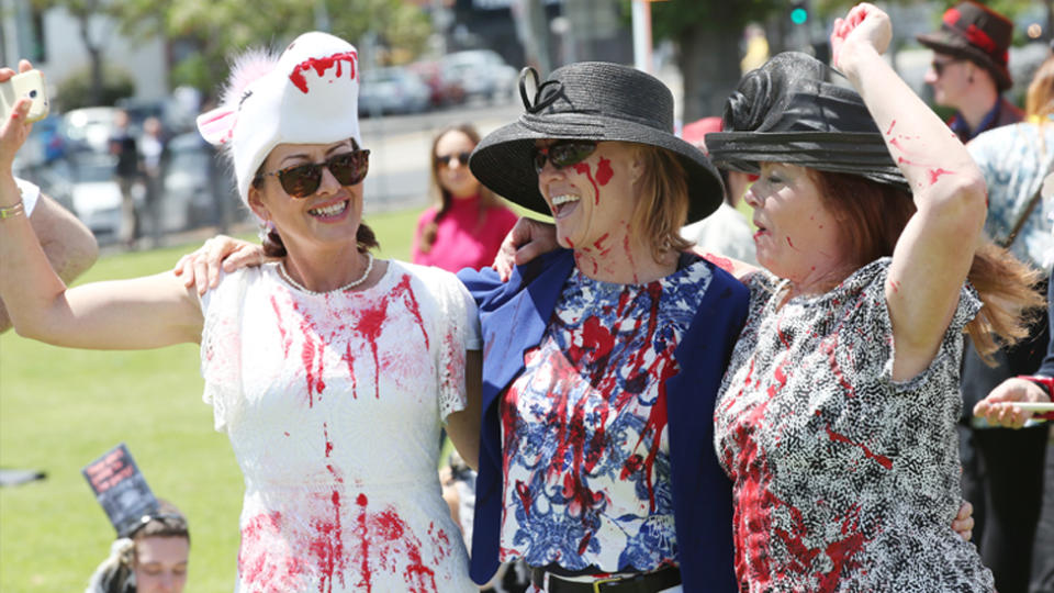 Protestors covered in blood stained clothes host their own fashions on the field as they protest the Melbourne cup