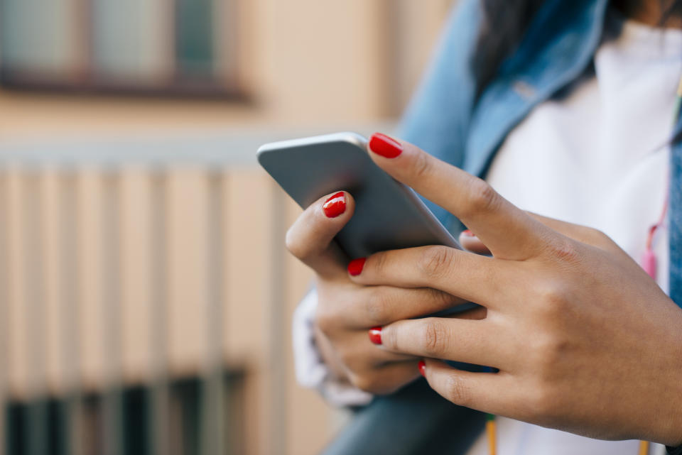 Close-up of a person's hands using a smartphone, with focus on the interaction