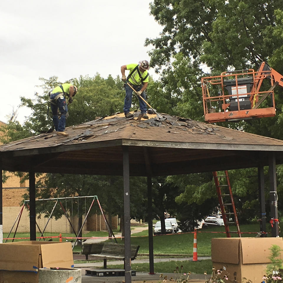 FILE - In this Wednesday, Sept. 14, 2016 file photo, workers scrape shingles from the gazebo where 12-year-old Tamir Rice was fatally shot by a Cleveland police officer, as crews prepare to dismantle the gazebo at a recreation center on the west side of Cleveland. The gazebo is being rebuilt in Chicago as a temporary memorial and meeting spot. (AP Photo/Mark Gillispie, File)