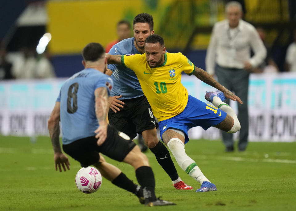 Brazil's Neymar, right, and Uruguay's Rodrigo Bentancur, center, and Uruguay's Nahitan Nandez fight for the ball during a qualifying soccer match for the FIFA World Cup Qatar 2022 at Arena da Amazonia in Manaus, Brazil, Thursday, Oct.14, 2021. (AP Photo/Andre Penner)