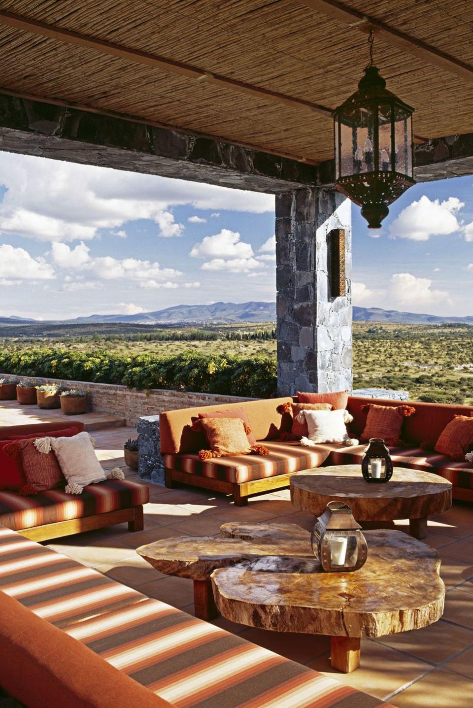 a patio with a table and chairs and a lamp on it