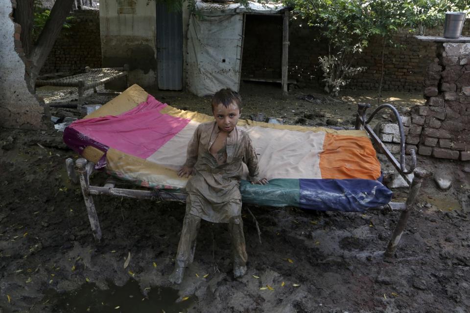 FILE - A boy stand in mud after floodwaters hit his home, in Charsadda, Pakistan, Aug. 31, 2022. The flooding in Pakistan killed at least 1,700 people, destroyed millions of homes, wiped out swathes of farmland, and caused billions of dollars in economic losses. In Khyber Pakhtunkhwa, residents had to rely on contaminated water, so now authorities are taking steps to prepare for the next disaster. (AP Photo/Mohammad Sajjad, File)