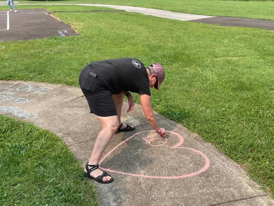 Connie Moore draws a heart for an uplifting message at the Pine Meadows Park. Sixteen-year-old Lafayette High School student Christopher Valdez was killed at the park.