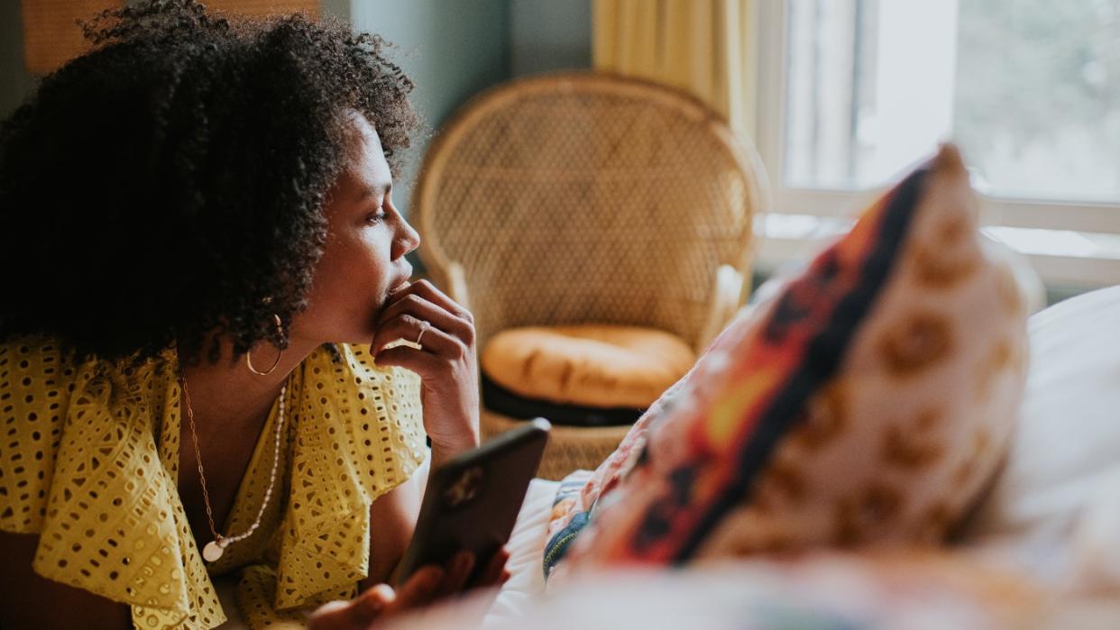  Woman on a sofa looking at her phone. 