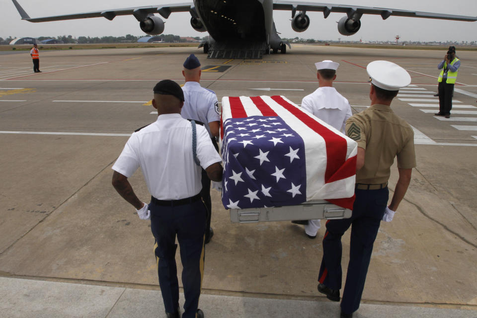 Four U.S. servicemen carry a coffin draped with the U.S. flag containing possible remains of a U.S. serviceman to a C-17 cargo plane during a repatriation ceremony at Phnom Penh International Airport, Cambodia, Wednesday, April 2, 2014. The possible remains of U.S. soldiers found in eastern Kampong Cham province were repatriated to Hawaii for testing. (AP Photo/Heng Sinith)