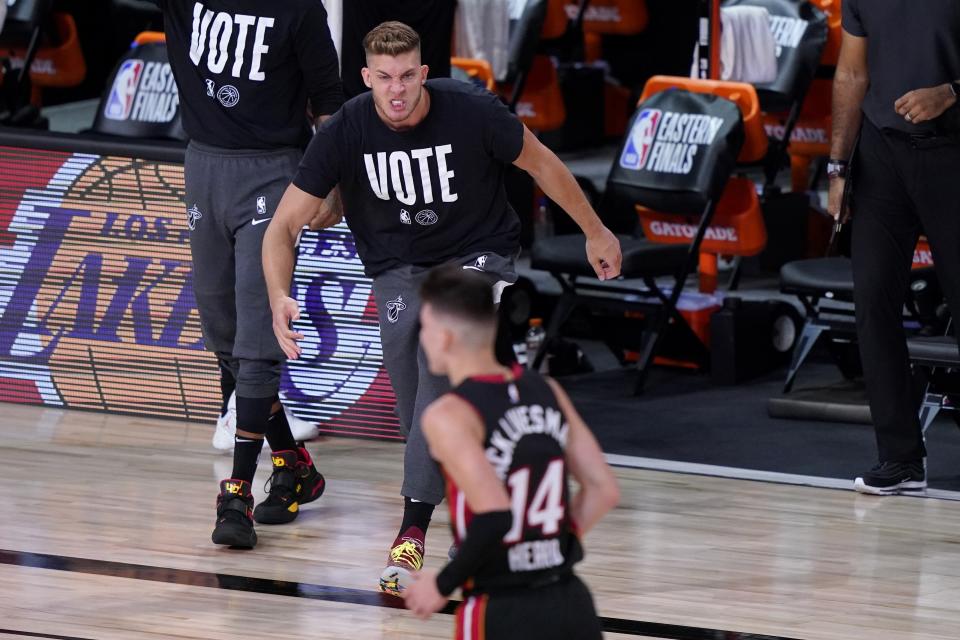 Miami Heat's Meyers Leonard, top, runs onto the court during a time out to celebrate with Tyler Herro (14) after Herro's 3-point basket against the Boston Celtics in the first half of an NBA conference final playoff basketball game, Saturday, Sept. 19, 2020, in Lake Buena Vista, Fla. (AP Photo/Mark J. Terrill)