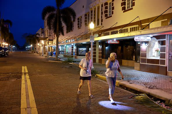 Carol Nies (left) and Heidi Smith survey the damage after Hurricane Ian passed through the area on September 29, 2022, in Fort Myers, Florida.