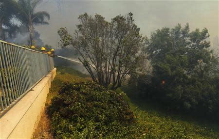 Firefighters battle the so-called Poinsettia Fire as it turns and heads east towards another subdivision of homes in Carlsbad, California May 14, 2014. REUTERS/Mike Blake