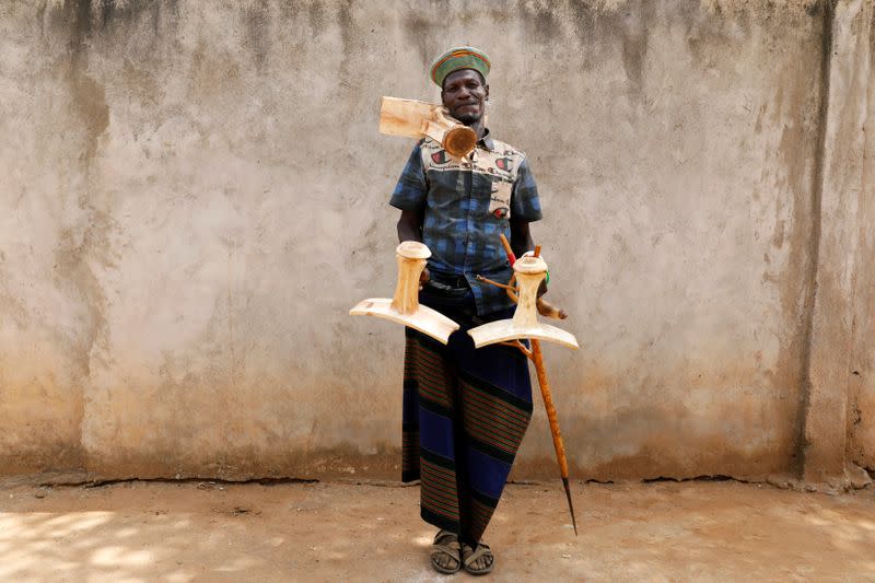 Edung' Loboche holds Ekicholongs, traditional Turkana stools that he is making, as he poses for a picture in the village of Lorengippi near the town of Lodwar, Turkana county