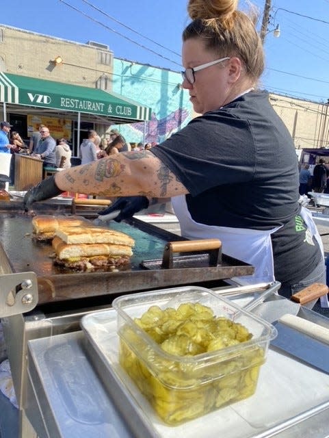 Mindy Boone, chef-owner of Mindy's Fat Stacks Grill, works in March preparing burgers for the crowd during the "OKC's Best Burger Competition & Tasting at VZD's Restaurant and Bar in Oklahoma City.