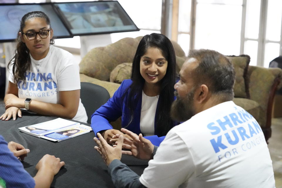 Shrina Kurani, a Democrat candidate for Congress running in the California's 41st District, center, talks to campaign volunteers, Field Director, Rasneek Singh, left, and Michael Ramlogan, right, at her field office on Saturday, May 28, 2022. As a congressional candidate in California, Shrina Kurani can do something candidates for statewide office or the state legislature cannot do, raise campaign donations through cryptocurrency. The state banned the practice four years ago, but under federal rules it's allowed for candidates running for Congress. (AP Photo/Damian Dovarganes)