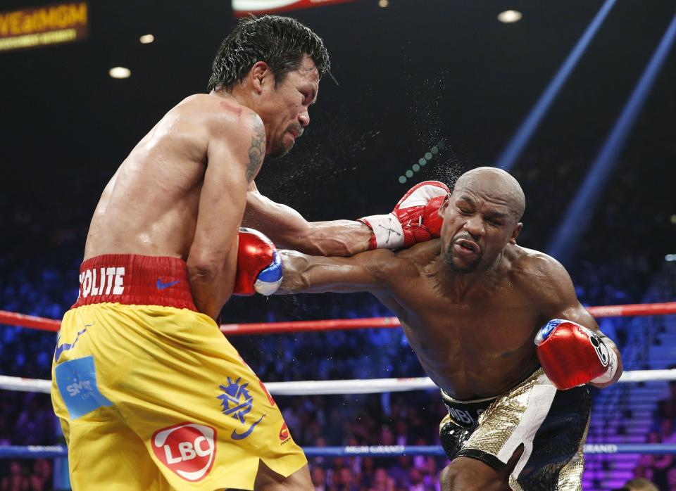 Manny Pacquiao, from the Philippines, left, trades punches with Floyd Mayweather Jr., during their welterweight title fight on Saturday, May 2, 2015 in Las Vegas. (AP Photo/John Locher)