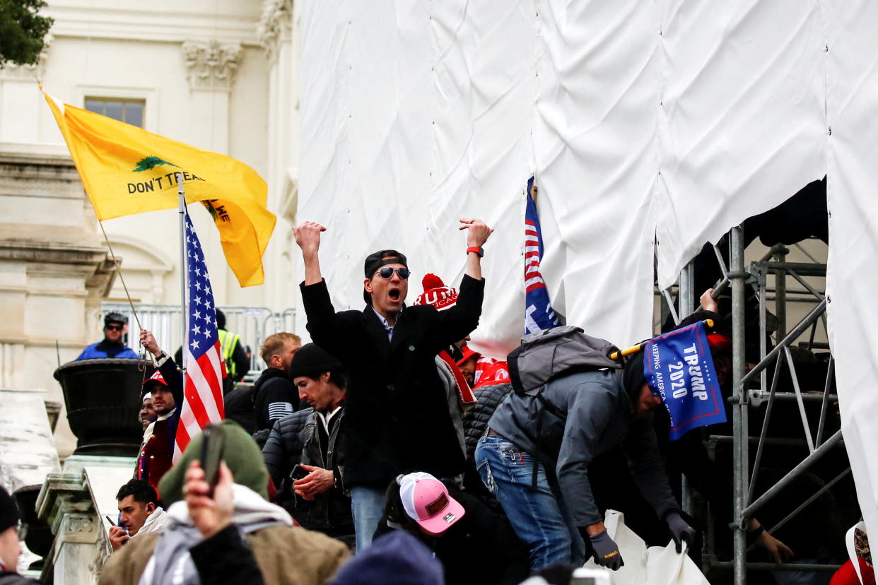 A man, identified as Ryan Kelley in a sworn statement by an FBI agent, gestures as supporters of U.S. President Donald Trump make their way past barriers at the U.S. Capitol during a protest against the certification of the 2020 U.S. presidential election results by the U.S. Congress, in Washington on January 6, 2021. (Jim Urquhart/Reuters)