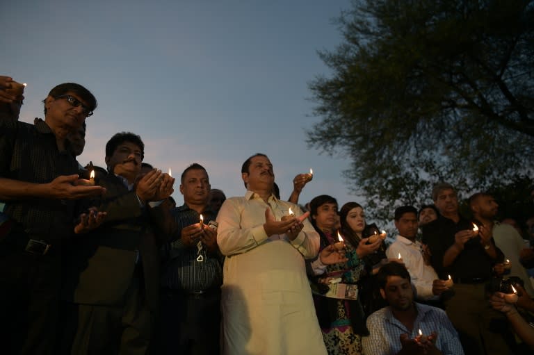 Pakistani journalists hold oil lamps during a vigil to pay tribute to their colleagues and lawyers who were killed a day after a suicide bombing at the Civil Hospital in Quetta, in Islamabad on August 9, 2016