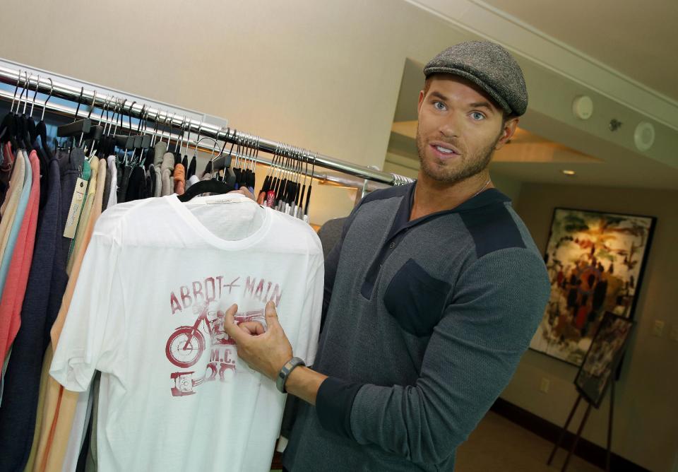 Actor and designer Kellan Lutz holds up an item from his pre-spring 2014 clothing line Abbot + Main at the Mandalay Bay Hotel on Monday, Aug. 19, 2013 in Las Vegas. (Photo by Isaac Brekken/Invision/AP)