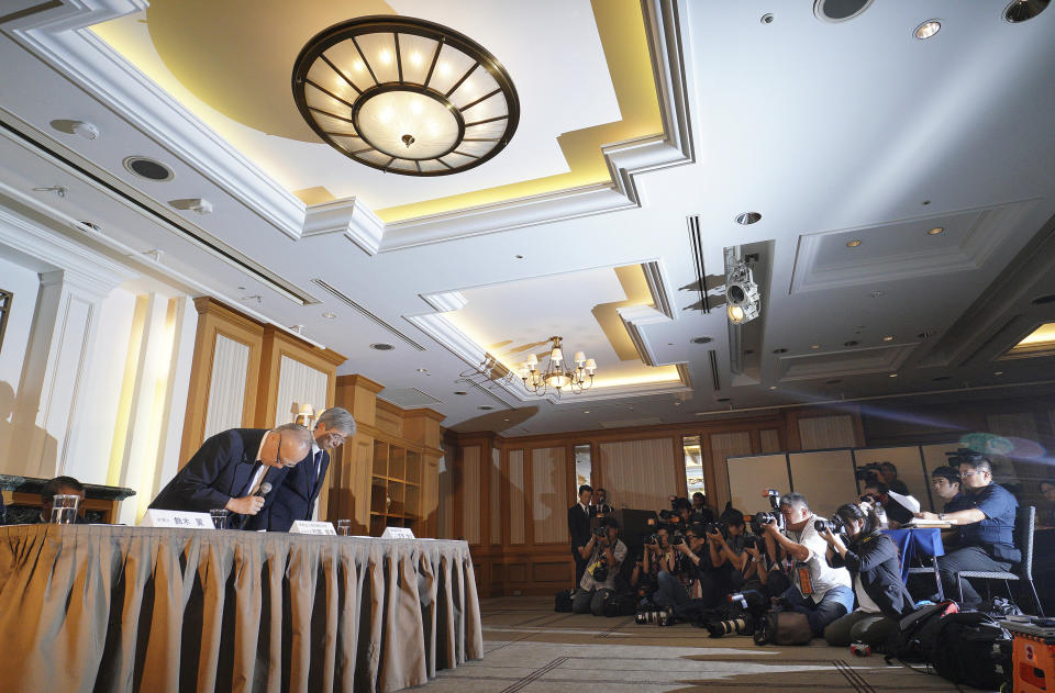 Tetsuo Yukioka, managing director of Tokyo Medical University, left, and Keisuke Tomizawa, a representative of the head of Tokyo Medical University, right, bow during a press conference Tuesday, Aug. 7, 2018, in Tokyo. The school has been investigating a reported allegation that it has discriminated against female applicants. (AP Photo/Eugene Hoshiko)