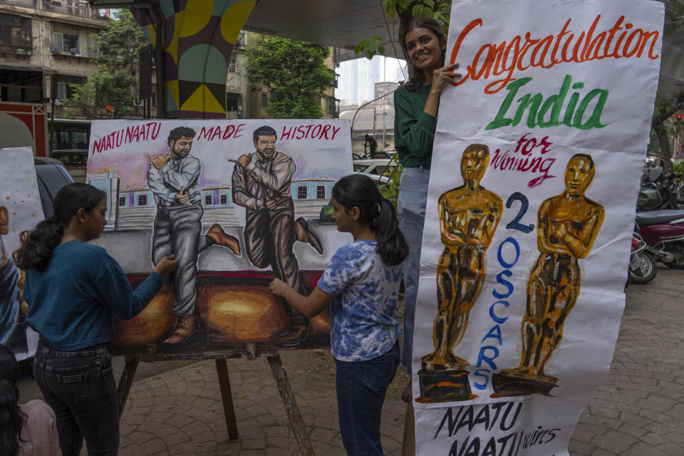 Estudiantes de una escuela de arte hacen pinturas en la calle para celebrar los dos premios Oscar de India en Bombay, India, el lunes 13 de marzo de 2023. India ganó Premios de la Academia por la canción original "Naatu Naatu" y por el cortometraje documental "The Elephant Whisperers". (Foto AP/Rafiq Maqbool)