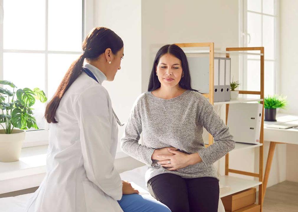 woman indicating stomach pain to gastronenterologist