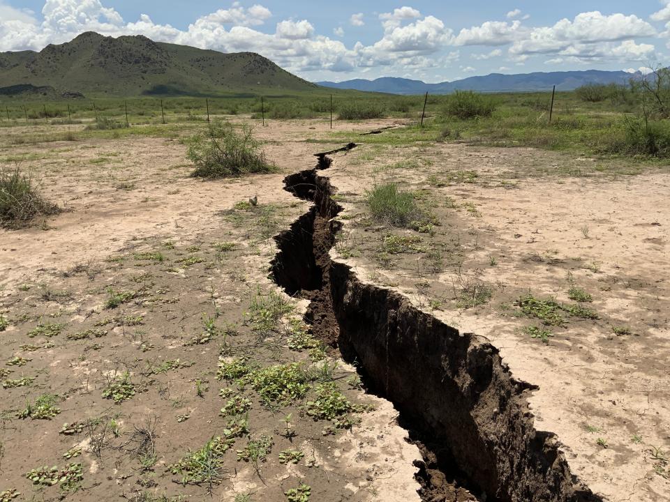 A ground fissure heads towards the mountain ranges near Sulphur Hills (southeast of Willcox Playa) on a bright desert day.