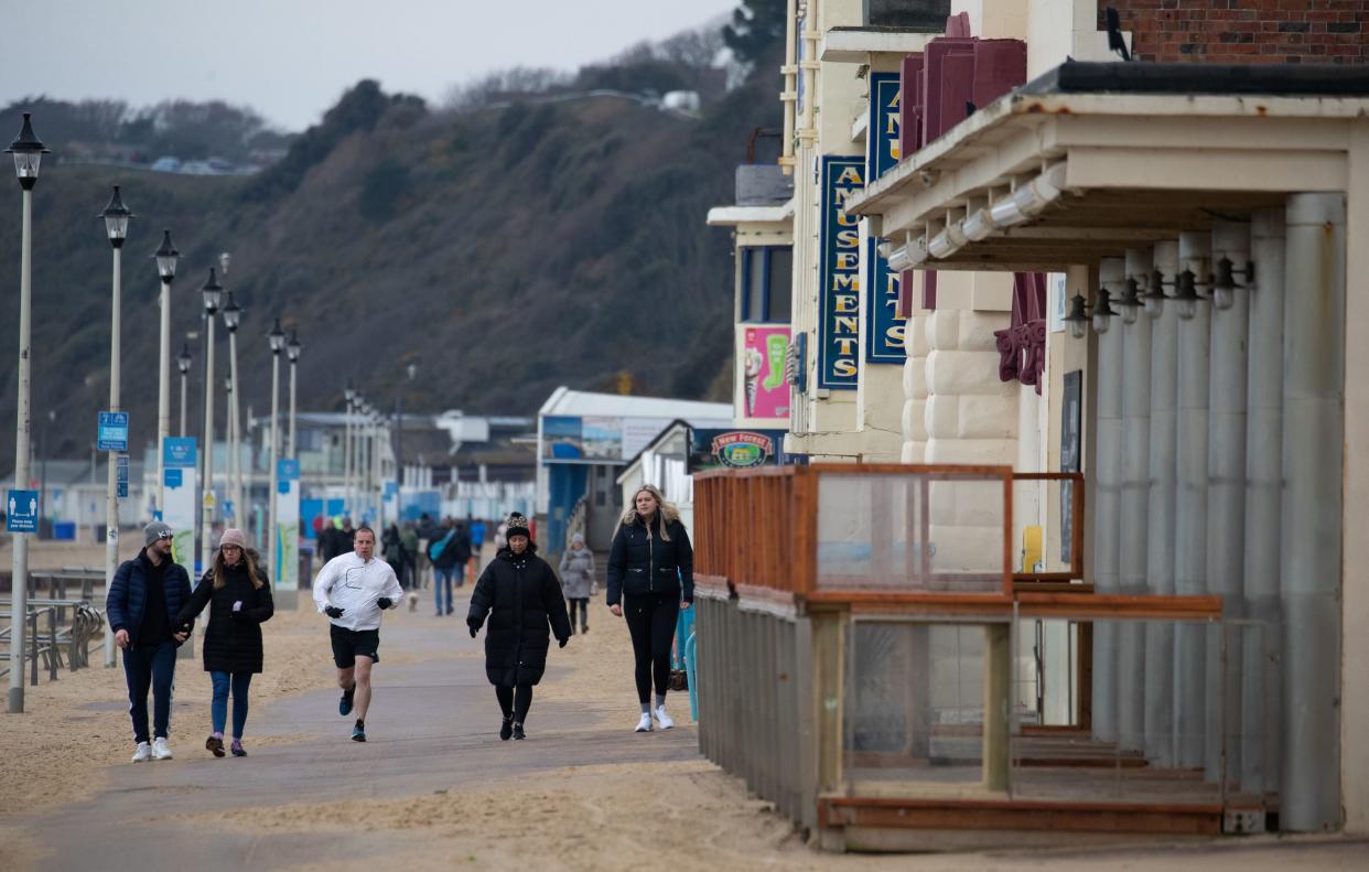 People exercise along the sea front on Bournemouth beach in Dorset during the third Covid lockdown (PA)