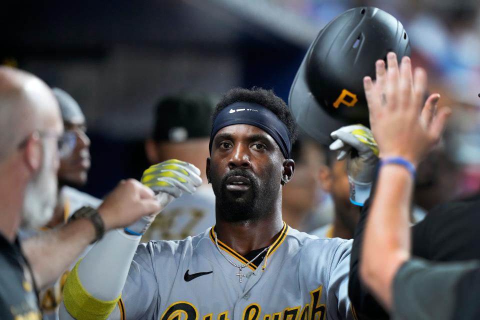 Pittsburgh Pirates' Andrew McCutchen is congratulated by teammates after he scored on a single by Carlos Santana during the ninth inning of a baseball game against the Miami Marlins, Friday, June 23, 2023, in Miami. (AP Photo/Wilfredo Lee)