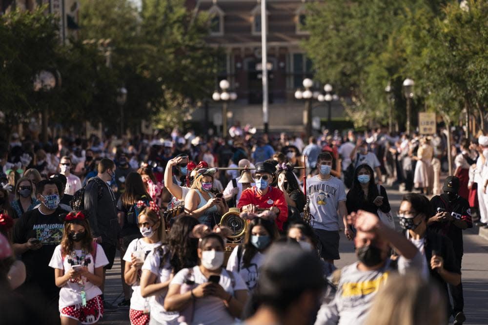 Guests walk along the Main Street USA at Disneyland in Anaheim, Calif., Friday, April 30, 2021. (AP Photo/Jae C. Hong)