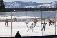 CORRECTS STATE TO NEVADA-Members of the Colorado Avalanche, in white, and the Vegas Golden Knights, red play during the first period of the Outdoor Lake Tahoe NHL hockey game in Stateline, Nev., Saturday, Feb. 20, 2021. (AP Photo/Rich Pedroncelli))