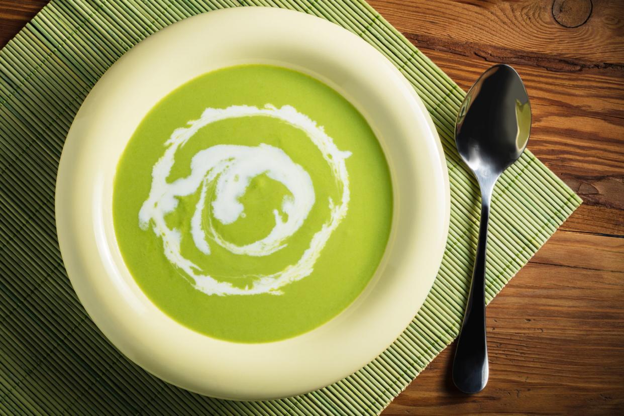 cream soup puree of green peas on wooden background