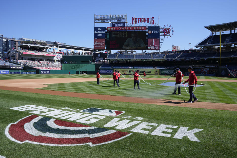 Groundskeepers prepare the field before an opening day baseball game between the Atlanta Braves and the Washington Nationals at Nationals Park, Thursday, March 30, 2023, in Washington. (AP Photo/Alex Brandon)