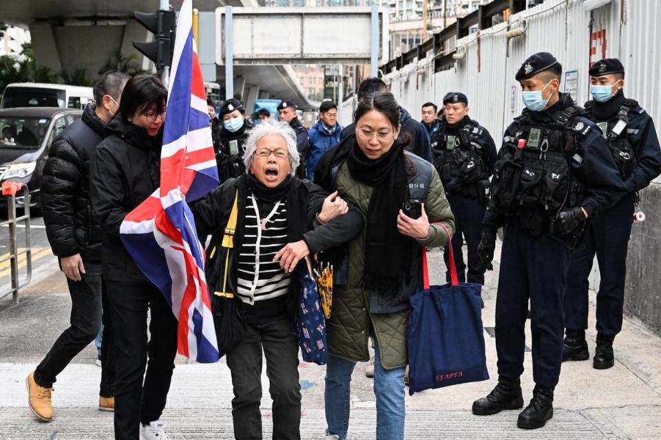 Police stop activist Alexandra Wong, centre, also known as Grandma Wong, as she carries a union jack outside court (AFP via Getty)