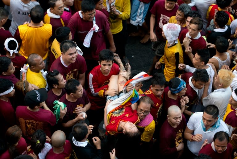 A female devotee is carried away after collapsing during an annual religious procession with the religious icon of the Black Nazarene in Manila on January 9, 2016