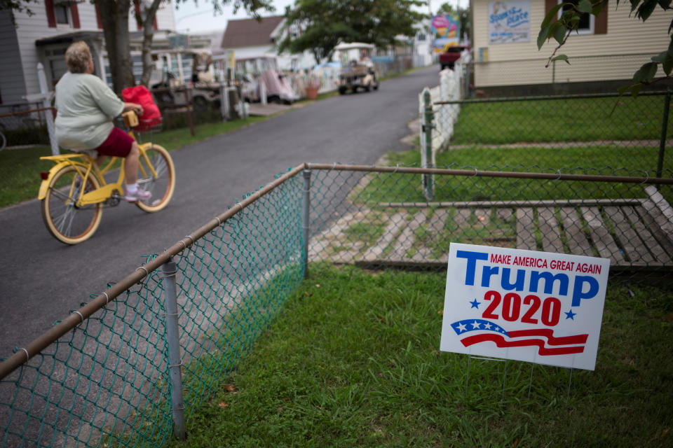 <p>A woman cycles past a house displaying a sign supporting U.S. President Donald Trump on Tangier Island, Virginia, Aug. 2, 2017. (Photo: Adrees Latif/Reuters) </p>