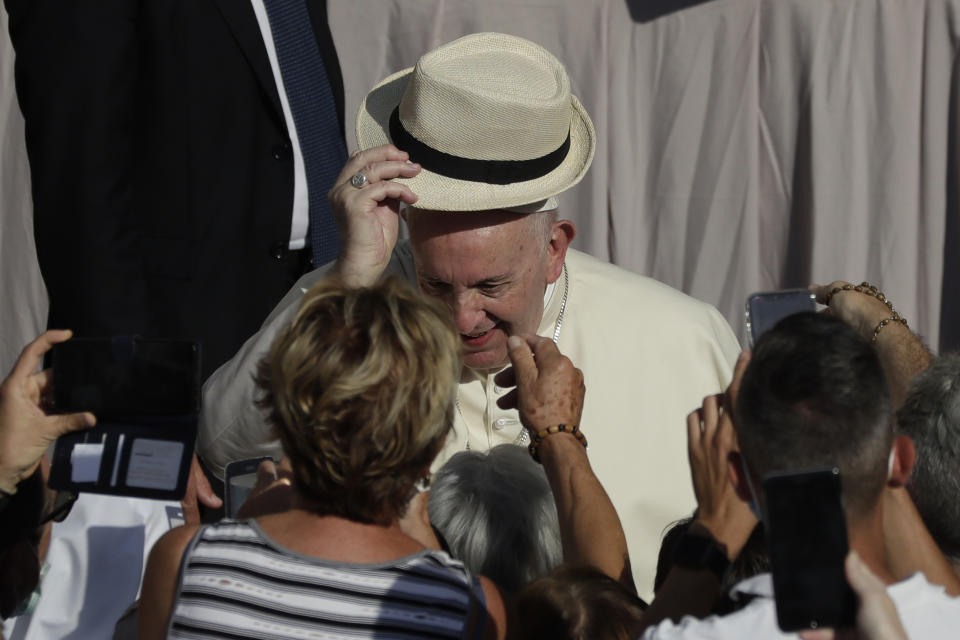 Pope Francis tries on a hat he was presented with as he arrives during his weekly general audience in San Damaso courtyard at the Vatican, Wednesday, Sept. 9, 2020. (AP Photo/Andrew Medichini)
