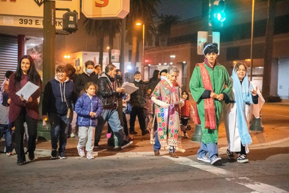 About 40 people march down Market Street while participating in the Mexican Heritage Center's annual Posada procession in downtown Stockton on Friday, Dec. 23, 2022. The event reenacts Mary and Joseph's search for lodging in Bethlehem just before the birth of Jesus. The Stockton Posada went from St. Mary's Church, stopping at a few places to be symbolically turned away, to the Mexican Heritage Center where they were welcomed in.