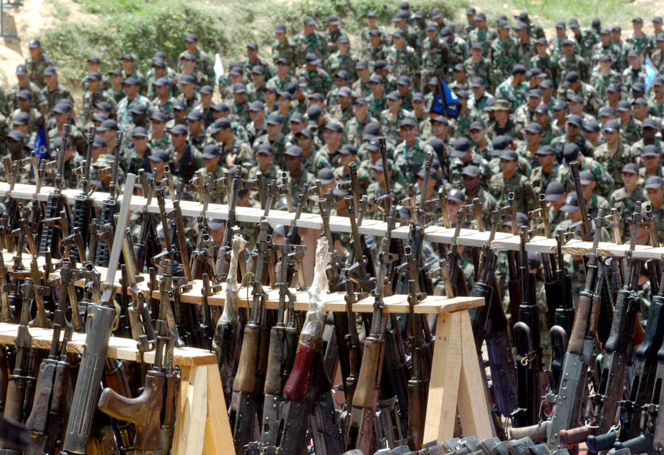 FILE - In this Aug. 1, 2005 file photo, paramilitary fighters from the "Heroes of Granada" faction of the United Self-Defense Forces of Colombia, or AUC, attend a demobilization ceremony in Cristales, Colombia. Hundreds of right-wing paramilitaries are expected to walk free from prison beginning in March 2014 after serving eight-year sentences for crimes that normally carry more than triple the prison terms. Their lenient sentences were enshrined in a 2005 “Justice and Peace” law that provided a legal framework for the militias’ supposed dismantling under a peace deal with the government of then-President Alvaro Uribe. (AP Photo/Luis Benavides, File)