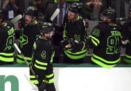 Dallas Stars defenseman Miro Heiskanen (4) fist bumps Tyler Seguin (91) after a goal against the Seattle Kraken during the third period in an NHL hockey game on Saturday, April 13, 2024, in Dallas. (AP Photo/Richard W. Rodriguez)