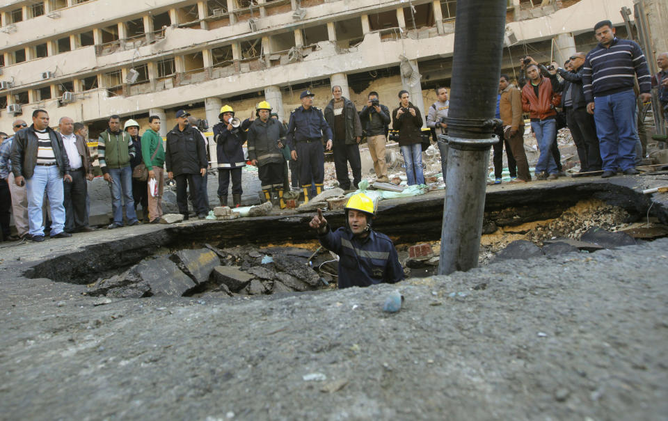 FILE - In this file photo taken Friday, Jan. 24, 2014, an Egyptian firefighter checks a crater made by a blast at the Cairo police headquarters in downtown Cairo, Egypt. On Saturday May 10, 2014. Egypt's chief prosecutor's office says it has charged 200 suspected militants with carrying out terrorist attacks that killed 40 policeman and 15 civilians, and of conspiring with al-Qaida and the Palestinian militant group Hamas in one of the country's largest terrorism-related cases. (AP Photo/Amr Nabil, File)