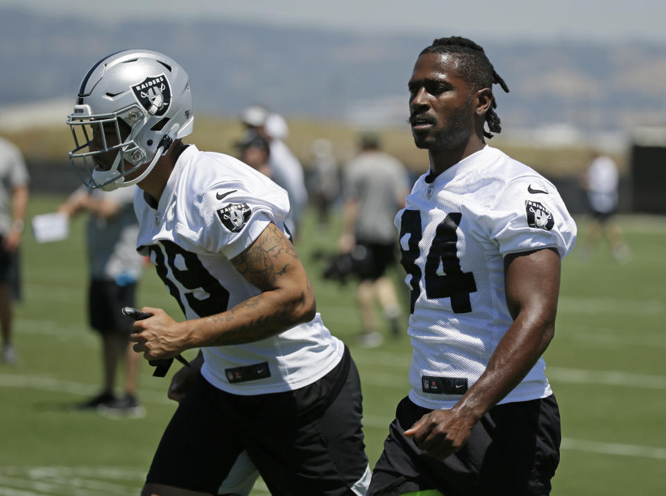 Oakland Raiders wide receivers Keelan Doss, left, and Antonio Brown warm up during NFL football minicamp Tuesday, June 11, 2019, in Alameda, Calif. (AP Photo/Eric Risberg)