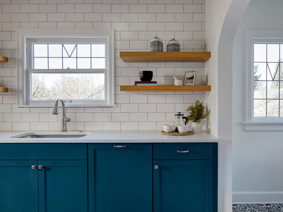 Painted blue cabinets in a kitchen with white counter and backsplash