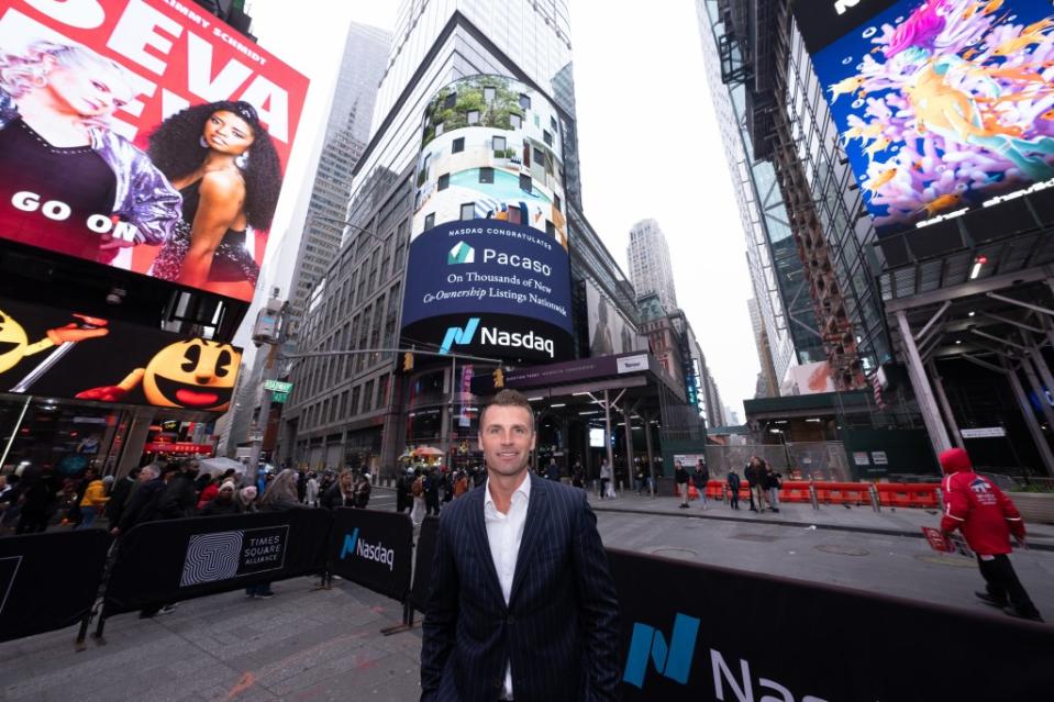 Pacaso CEO Austin Allison in front of a Pacaso billboard in Times Square