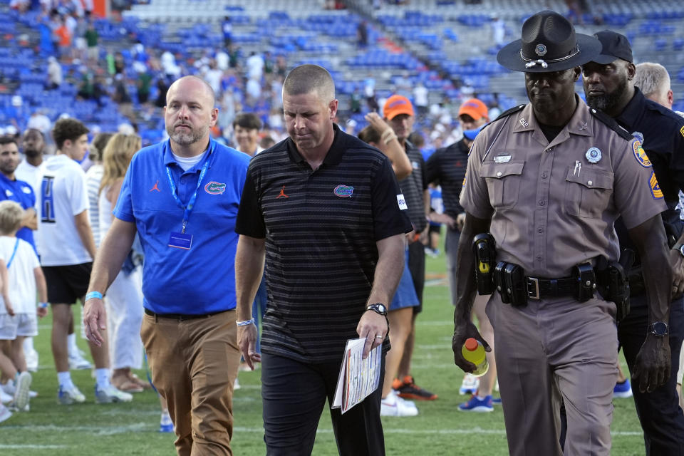 Florida head coach Billy Napier (center) walks off the field after his team was defeated 41-17 by Miami in an NCAA college football game, Saturday, Aug. 31, 2024, in Gainesville, Fla. (AP Photo/John Raoux)