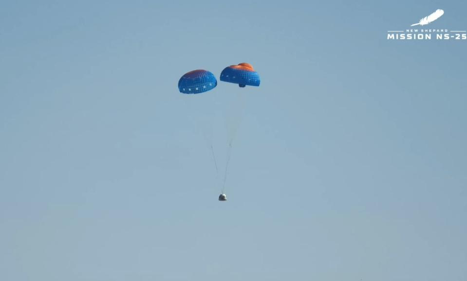 Man sieht, wie die Mannschaftskapsel von Blue Origin mit zwei eingesetzten Fallschirmen zur Erde absteigt